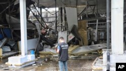 Украинский прокурор по военным преступлениям осматривает место российского ракетного обстрела в Одессе, Украина, 14 июня 2023 года.