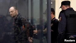 مأموران پلیس روسیه ولادیمیر کارا مورزا، روزنامه‌نگار منتقد کرملین، را با دستبند به جلسه محاکمه می‌برند – اول مرداد ۱۴۰۲، عکس از آسوشیتدپرس