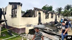 ২০২৩ সালের ২২ মে সোমবার গায়ানার পাবলিক ইনফরমেশন বিভাগের দেয়া এই ছবিতে দেখা যাচ্ছে, মাহদিয়াতে একটি মাধ্যমিক বিদ্যালয়ের ছাত্রাবাস আগুনে পুড়ে গেছে।