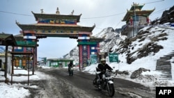 মোটরবাইক আরোহীরা উত্তর-পূর্ব ভারতের অরুণাচল প্রদেশের তাওয়াং-এর বরফাবৃত হিমালয় অঞ্চলের সেলা গিরিপথ পার হচ্ছে ; ৫ এপ্রিল ২০২৩ তোলা ছবি।