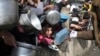 FILE - Palestinians receive aid during the Israeli offensive on the Gaza Strip in Rafah, Jan. 9, 2024. Supplies of food are now at risk, and those displaced by the offensive face a public health crisis, a senior U.N. official said June 14, 2024.