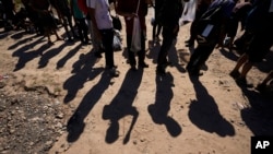 FILE - Migrants wait to be processed by authorities after entering the U.S. from Mexico, Oct. 19, 2023, in Eagle Pass, Texas. Preliminary figures released June 20, 2024, show a sharp drop in migrant arrests since new asylum restrictions were announced.
