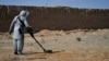 FILE - This picture taken on Nov. 9, 2021 shows a deminer from the HALO (Hazardous Area Life-Support Organization) Trust scanning the ground for mines with a metal detector in Nad-e-Ali village in Helmand province. 