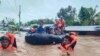 rescue workers evacuating people from a flooded area due to heavy rain brought by Tropical Storm Nalgae in Parang, Maguindanao province. (AFP Photo/Philippine Coast Guard)