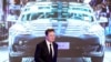 FILE - Tesla Inc CEO Elon Musk walks next to a screen showing an image of Tesla Model 3 car during an opening ceremony for Tesla China-made Model Y program in Shanghai, China, Jan. 7, 2020.