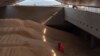 FILE - A crew member prepares a grain analysis onboard a ship coming from Ukraine loaded with grain and anchored in Istanbul, on Oct. 11, 2022.