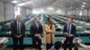 New York City Emergency Management Commissioner Zach Iscol, far right, and other officials talk with reporters in the sleeping area of the city's latest temporary shelter on Randall's Island, Oct. 18, 2022.