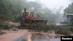 এল সাভাদরের কোমাসাগুয়ায় গ্রীষ্মমণ্ডলীয় ঝড় জুলিয়ার প্রভাবে হওয়া একটি ভূমিধসে সেনারা নিহত হয়। ঘটনাস্থলের কাছে একটি ট্রাক্টর কাজ করছে। ১০ অক্টোবর, ২০২২।