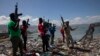 FILE - Armed men are seen near the perimeter wall that encloses the currently blockaded Terminal Varreux, in Port-au-Prince, Haiti, Oct. 6, 2021.