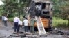 People inspect a bus that caught fire on a highway in Nashik, in the western Indian state of Maharashtra, Oct. 8, 2022.