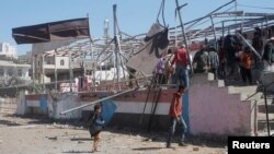 People gather at the scene of a blast which struck a military graduation parade in the town of al-Dhalea, Yemen, Dec. 29, 2019. 