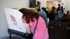 FILE - A voter leans into a booth while filling out her ballot during the 2022 midterm elections in Chapel Hill, North Carolina, Nov. 5, 2022.