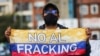 Un hombre sostiene una bandera colombiana con la frase "No al fracking" durante una protesta organizada por Miembros de Extinction Rebellion contra los proyectos piloto de fracking, en el Día de la Tierra en Bogotá. , Colombia, 22 de abril de 2022.