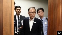  တောင်ကိုရီးယားသမ္မတဟောင်း Lee Myung-bak ဆိုးလ်မြို့တော်တရားရုံးမှာ ပထမဆုံးရုံးထုတ်စစ်ဆေးချိန်။ (မေ ၂၃၊ ၂၀၁၈)