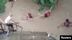 A rescuer helps people affected by floods in Gingoog city, Philippines, Dec. 25, 2022. (Philippine Red Cross/Twitter/via Reuters) 