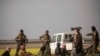 Sujetos sospechosos de ser combatientes del Estado Islámico llegan a un centro de investigación en Baghuz, Siria.