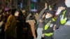 This frame grab from eyewitness video footage made available via AFPTV on November 27, 2022 shows demonstrators shouting slogans as police hold their positions, in Shanghai.