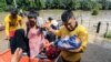 People affected by floods after the passage of Tropical Storm Julia, arrive at safe place after being evacuated by boat, in the municipality of Choloma, department of Cortes, Honduras, Oct. 10, 2022.
