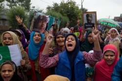 FILE - Kashmiris protest after Friday prayers against the abrogation of article 370, near Srinagar, Indian-controlled Kashmir, Oct. 4, 2019.