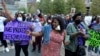 Ayisyen Ameriken chante slogan pandan yon manifestasyon nan Boston, 24 Sept. 2021