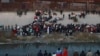 Migrants gather at a crossing into El Paso, Texas, as seen from Ciudad Juarez, Mexico, Dec. 20, 2022. 