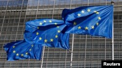 FILE - European Union flags flutter outside the EU Commission headquarters in Brussels, Belgium, June 17, 2022.