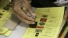 A man stamps his early ballot at Hnin Si Kone Old Aged Center in Yangon, Myanmar, Nov 6, 2015. 