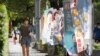 People walk past candidate's campaign flag in Taipei, Taiwan, Sunday, Nov. 20, 2022. Taiwan will hold local elections on November 26. (AP Photo/Chiang Ying-ying)