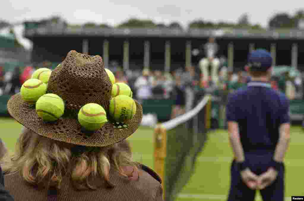 Seorang penonton dari luar lapangan melihat pertandingan di Kejuaraan Tenis Wimbledon, di London.