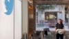 This image from the Twitter page of Elon Musk shows Musk entering Twitter headquarters carrying a sink through the lobby area, Oct. 26, 2022 in San Francisco. 
