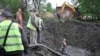 Працівники комунальних служб працюють біля вирви у дворі лікарні в Харкові після російського масованого ракетного удару по Україні, що пошкодив чотири електростанції. 27 квітня 2024 року.