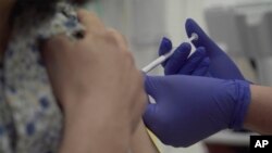 Seseorang disuntik sebagai bagian dari uji coba manusia pertama di Inggris untuk menguji vaksin virus corona, Kamis, 23 April 2020. (Foto: AP)