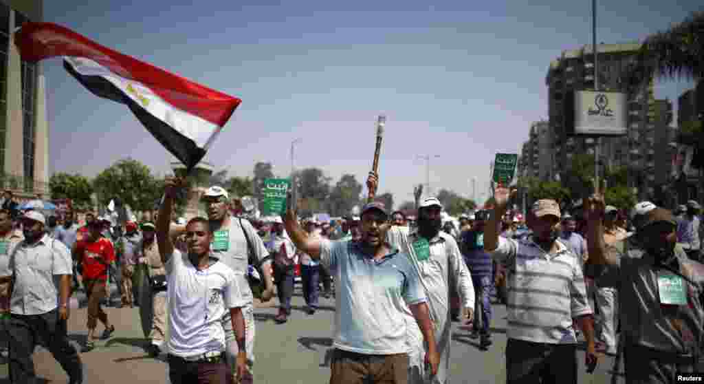 Para pendukung mantan presiden Mohamed Morsi berjalan dari daerah Raba El-Adwyia menuju markas militer Republican Guards tempat ia diyakini ditahan (7/7). (Reuters/Khaled Abdullah)