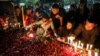 Suporter klub sepak bola Arema menyalakan lilin di luar stadion Kanjuruhan untuk menyampaikan belasungkawa kepada para korban pasca kerusuhan di Stadion Kanjuruhan, Malang, Jawa Timur, Minggu 2 Oktober 2022. 