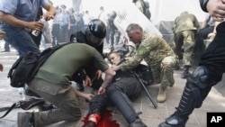 Seorang polisi Ukraina terluka akibat ledakan granat ketika terjadi bentrokan dengan para demonstran di Kyiv, Senin (31/8).