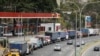 Camiones de remolque se alinean a lo largo de una avenida para llenar sus tanques en una estación de servicio en medio de la escasez de diesel, en Caracas, Venezuela. Marzo 5, 2021. Foto: Reuters.