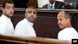 Baher Mohamed, Produser Al-Jazeera (kiri), wartawan Kanada keturunan Mesir Mohammed Fahmy (tengah) dan koresponden Peter Greste (kanan) di pengadilan Kairo, Mesir (Foto: dok). 