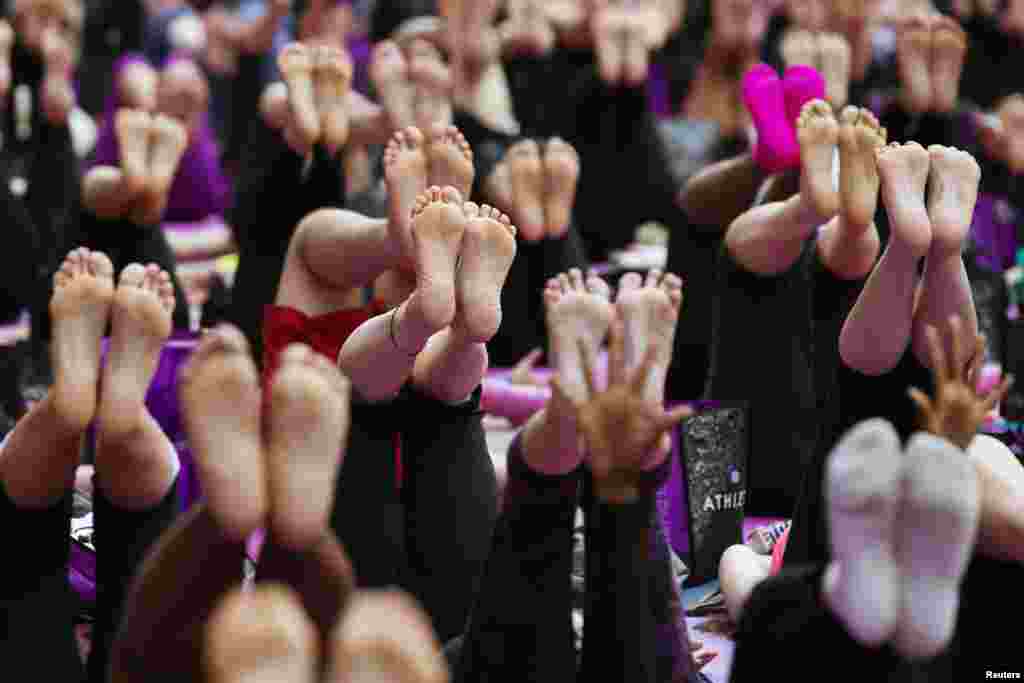 Sejumlah orang ambil bagian dalam sebuah latihan yoga pada pagi hari bertepatan dengan awal musim panas di New York Times Square. Acara 'Solstice di Times Square' mengajak ribuan pesertanya untuk memperingatihari terpanjang dalam tahun ini.