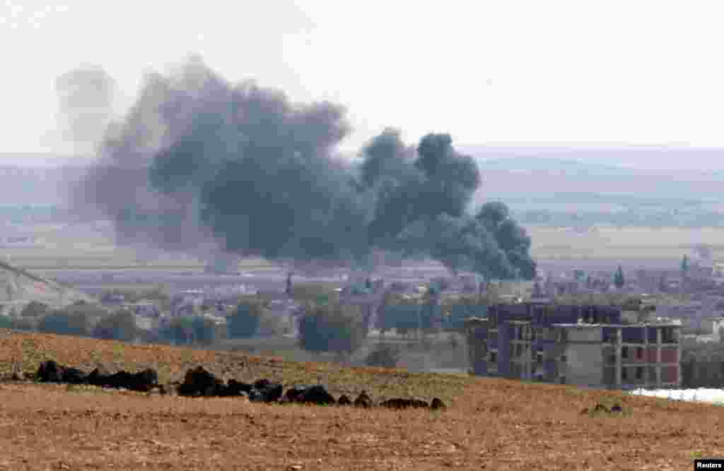 Smoke rises from the Syrian town of Kobani, as seen from near the Mursitpinar border crossing on the Turkish-Syrian border in Suruc, Oct. 6, 2014.