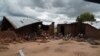 Victims of mob attacks sitting outisde their demolished houses on suspicion that they are withholding rains.