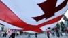 FILE - Georgians carry a giant national flag during a 2008 demonstration in Tbilisi, Georgia.