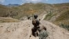 FILE - An Afghan border policeman is seen patrolling a section of the frontier between Afghanistan and Pakistan.