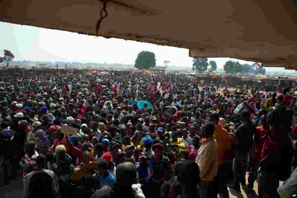 People wait to receive food and supplies from an aid distribution point set up inside a makeshift camp at Mpoko Airport in Bangui, Jan. 7, 2014.