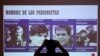 Un miembro de una organización de derechos humanos toma una fotografía de una pantalla que muestra a cuatro periodistas holandeses asesinados por las Fuerzas Armadas de El Salvador en el 39 aniversario del crimen, en San Salvador, el 17 de marzo de 2021.