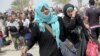 Displaced Sunni women fleeing the violence in Ramadi, carry bags as they walk on the outskirts of Baghdad, May 24, 2015. 