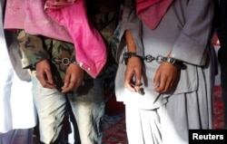 Dua pria yang diborgol, yang menurut polisi termasuk dalam kelompok Tehreek-e-Taliban Pakistan [TTP], ditunjukkan dalam konferensi pers di Departemen Investigasi Kejahatan setelah ditangkap di Karachi, Januari 2013. (Foto: dok).