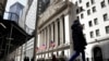 FILE PHOTO: People are seen on Wall St. outside the NYSE in New York