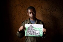 Jean Claude Masengesho holds one of his many drawings of silverback gorillas in Kinigi, Rwanda, Sept. 5, 2019.