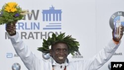 Eliud Kipchoge célèbre son trophée après avoir remporté le marathon de Berlin, Allemagne, le 16 septembre 2018