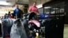 FILE - Natalie Pereira (C) queues to go through migration before her move to the U.S. with her family, after winning the Green Card lottery, at the Maiquetia airport in Caracas, April 8, 2014. 
